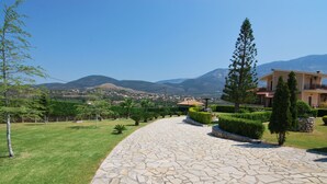 A stone pathway leading to a building with a view of mountains. - First floor independent apartment with amazing views & private pool in Pessada (Livathos)