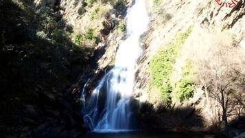 Une cascade se déversant en contrebas d’une falaise rocheuse dans un bassin.