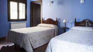 A bedroom with two beds, a window, a door, and a wall-mounted lamp. - Rural apartment Ramajal Rural for 4 people (Pinofranqueado)
