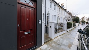 A row of white terraced houses with a red door on the left. - Stunning Kensington Studio, Central London (London)