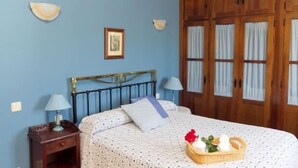 Ein Schlafzimmer mit einem Bett, einem Holzschrank und einem Nachttisch mit Lampe.