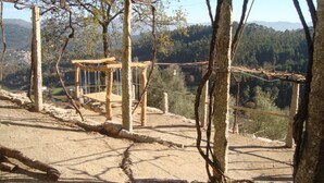 A wooden swing set in a natural setting with a view of a forested valley. - Quinta da Vinagra, sunny and modest space for up to 6 people (arcos de valdevez)