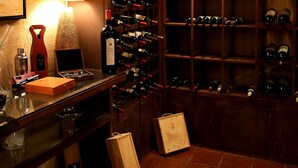 Uma adega com prateleiras de garrafas de vinho, um suporte para vinhos e uma caixa de madeira.