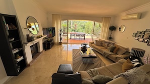 Ein Wohnzimmer mit einer Couch, einem Couchtisch, einem Fernseher und einem Kamin.
