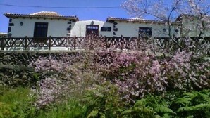 A traditional building with a stone wall and a wooden fence.