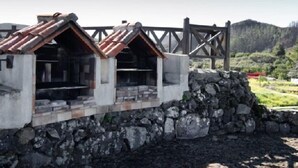 A stone structure with a wooden roof and a stone wall.