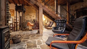 A spacious interior with a stone floor, wooden staircase, and leather chairs. - Mill rehabilitated with Natural Pool and Barbecue in natural environment  (Pinofranqueado)
