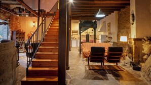 A rustic interior with a stone floor, wooden staircase, and a dining area with chairs and a table. - Mill rehabilitated with Natural Pool and Barbecue in natural environment  (Pinofranqueado)