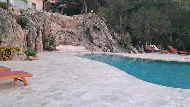 A pool with a stone patio and lounge chairs. - LA VILLA GIULIA IN PORTO CERVO (OLBIA TEMPIO)