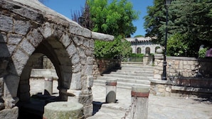 Un vialetto in pietra con un ingresso ad arco che conduce a un edificio con tetto a tegole.