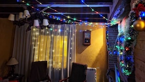 Una camera accogliente con soffitto in legno rustico, un termosifone e una finestra con tende.