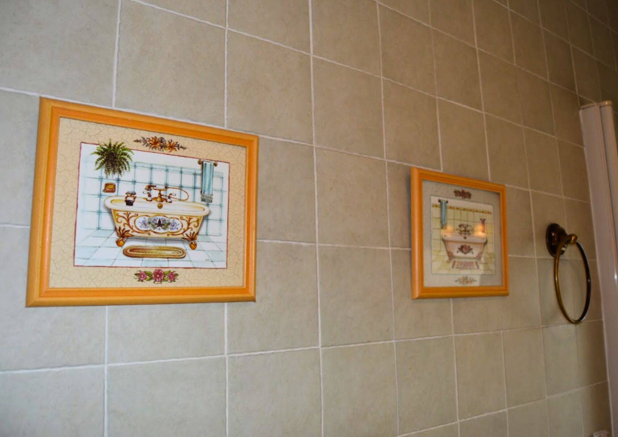 Dos fotografías enmarcadas de lavamanos antiguos sobre una pared de azulejos.
