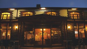 A restaurant with a brick facade, large windows, and outdoor seating. - Black Spur Inn (Narbethong)