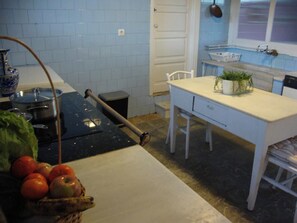 A kitchen with a white table, a sink, and a window. - Self catering La Casona de la Garaba for 14 people (Grado)