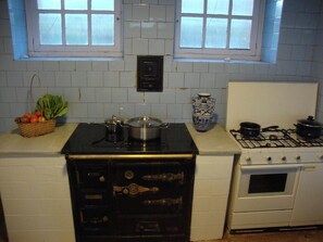 A kitchen with a stove, oven, and a black cabinet with drawers.