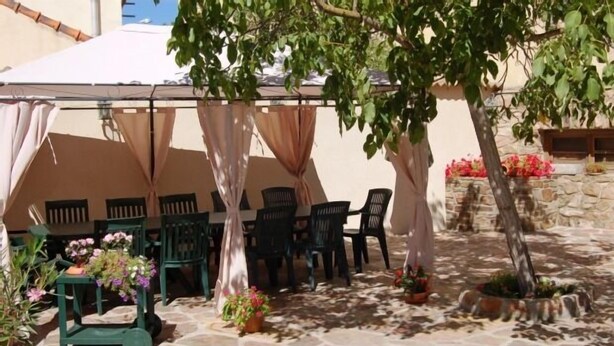 An outdoor patio area with stone flooring, green chairs, and potted plants. - Cottage Sunsets for 16 people (full rental) (Migueláñez)
