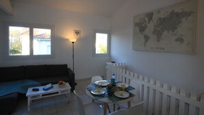 Ein Essbereich mit einem weißen Tisch für zwei Personen, einem weißen Zaun und einer Weltkarte an der Wand.