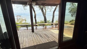 A wooden deck with a view of the sea and trees. - Bayfront Lodge-Beautiful & Unique East Bay Retreat (Gulf Breeze)