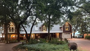 A two-story house with a front porch, a garage, and a well-maintained garden. - Bayfront Lodge-Beautiful & Unique East Bay Retreat (Gulf Breeze)