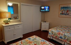 A bedroom with a bed, a dresser, a television, and a painting on the wall. - Oasis #504 Free Beach Service Included - 2 Chairs and Umbrella 2-Bd 2-Bath (Destin)
