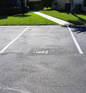 A parking lot with white lines and a faded number '1302' on the asphalt. - Sunsets #1502 Chateau La Mer II 2Bd-2Bath Ground Floor (Destin)