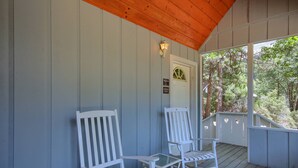 A covered porch with two white rocking chairs and a glass table. - (43R) Edna's Hearts Desire at The Redwoods In Yosemite (Wawona)