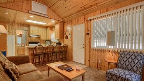 A cozy cabin interior with a living room, dining area, and kitchen. - (43R) Edna's Hearts Desire at The Redwoods In Yosemite (Wawona)