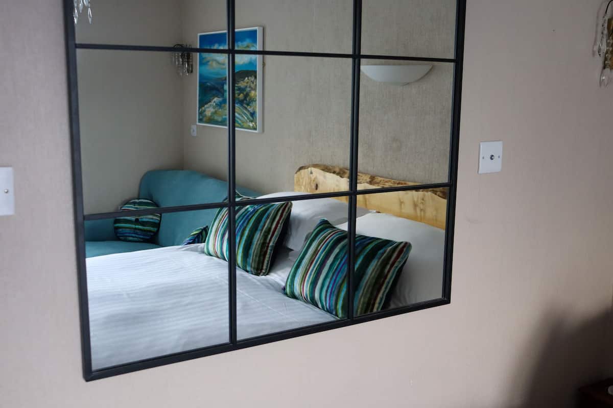 Une chambre à coucher avec un lit, une table de chevet, une lampe et un tableau au mur.
