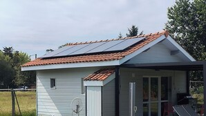 A small, single-story house with a sloped roof, a satellite dish, and a covered porch area. - Chalet 4 people with shared pool (Hourtin)