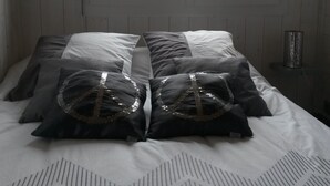 A bedroom with a bed, pillows, a window, and a nightstand. - Chalet 4 people with shared pool (Hourtin)