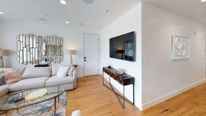 Ein modernes Wohnzimmer mit Sofa, Couchtisch und Wandbildern.