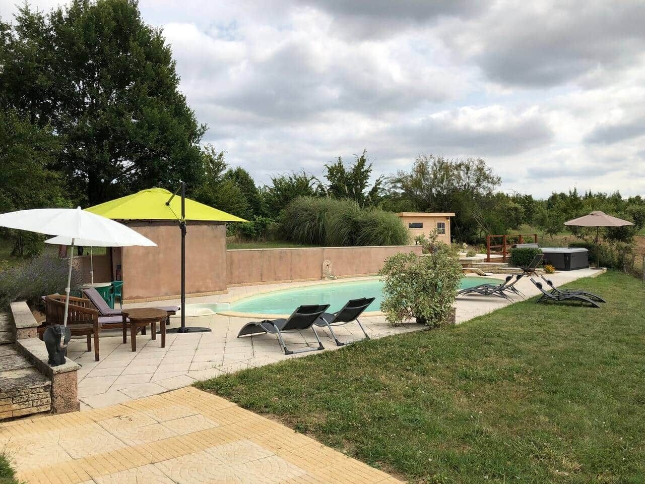 Un jardin avec une piscine, des chaises longues et un patio couvert.