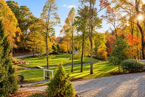 A well-maintained garden with a lawn, a seating area, and a gravel path.