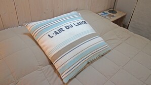 A bed with a pillow that reads "L'Air du Large." - Le Clos des Flots, The Fleet - House "L'Océan" - 2 bedrooms, private patio (La Flotte)