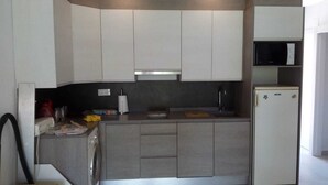 Une cuisine moderne équipée d’un lave-linge, d’un four à micro-ondes et d’un réfrigérateur.
