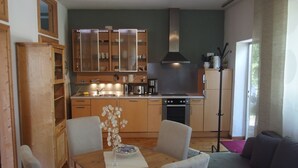 Una cocina moderna con armarios de madera, una mesa de comedor con sillas y un horno empotrado.