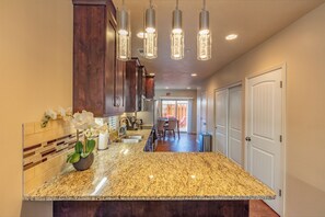 Kitchen features a large island, oven, and dark cabinets.