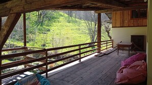 Une terrasse en bois offrant une vue sur une colline verdoyante.