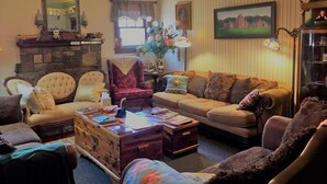 A cozy living room with a fireplace, comfortable seating, and a bookshelf. - Hunterston Cottage -Sleeps 6 - Ft. Sill, Wichita Mountains, Casinos (Lawton)