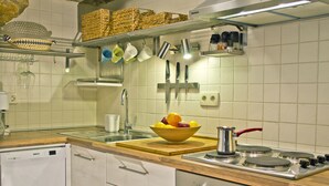 A kitchen with a dishwasher, stove, and various utensils.