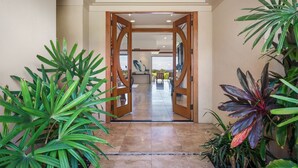 A hallway with wooden doors leading to a dining area.