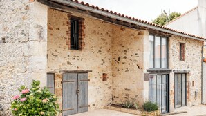 A rustic stone building with two wooden doors and a small window. - Cottage 7 people near Puy du Fou (Sèvremont)