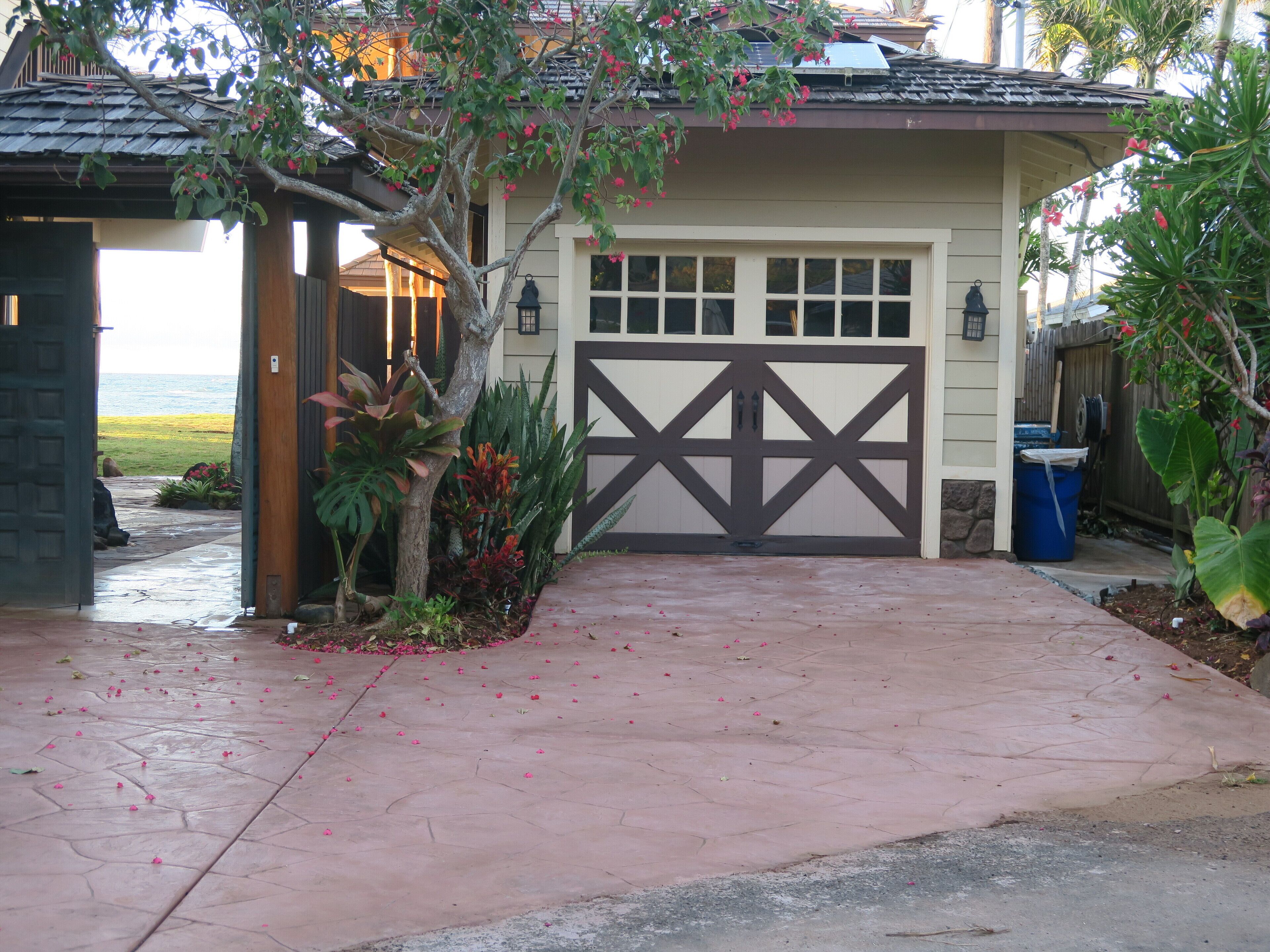 A house with a garage, a covered porch, and a view of the ocean.