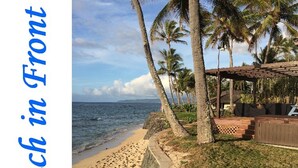 A beach with a pathway leading to a covered seating area.
