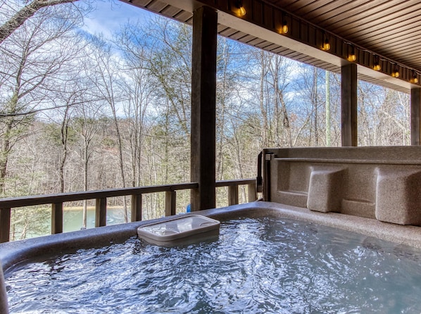 A hot tub with a view of a forest.