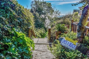 A pathway leading to a beach area with a sign reading "LIFE'S A BEACH". - Seacliff Beach Home (Aptos)