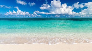 A beach with clear turquoise water and white sand.