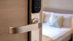 A modern hotel room with a wooden door featuring a digital keypad lock. - Casa Vacanze Carolina 348 (Naples)