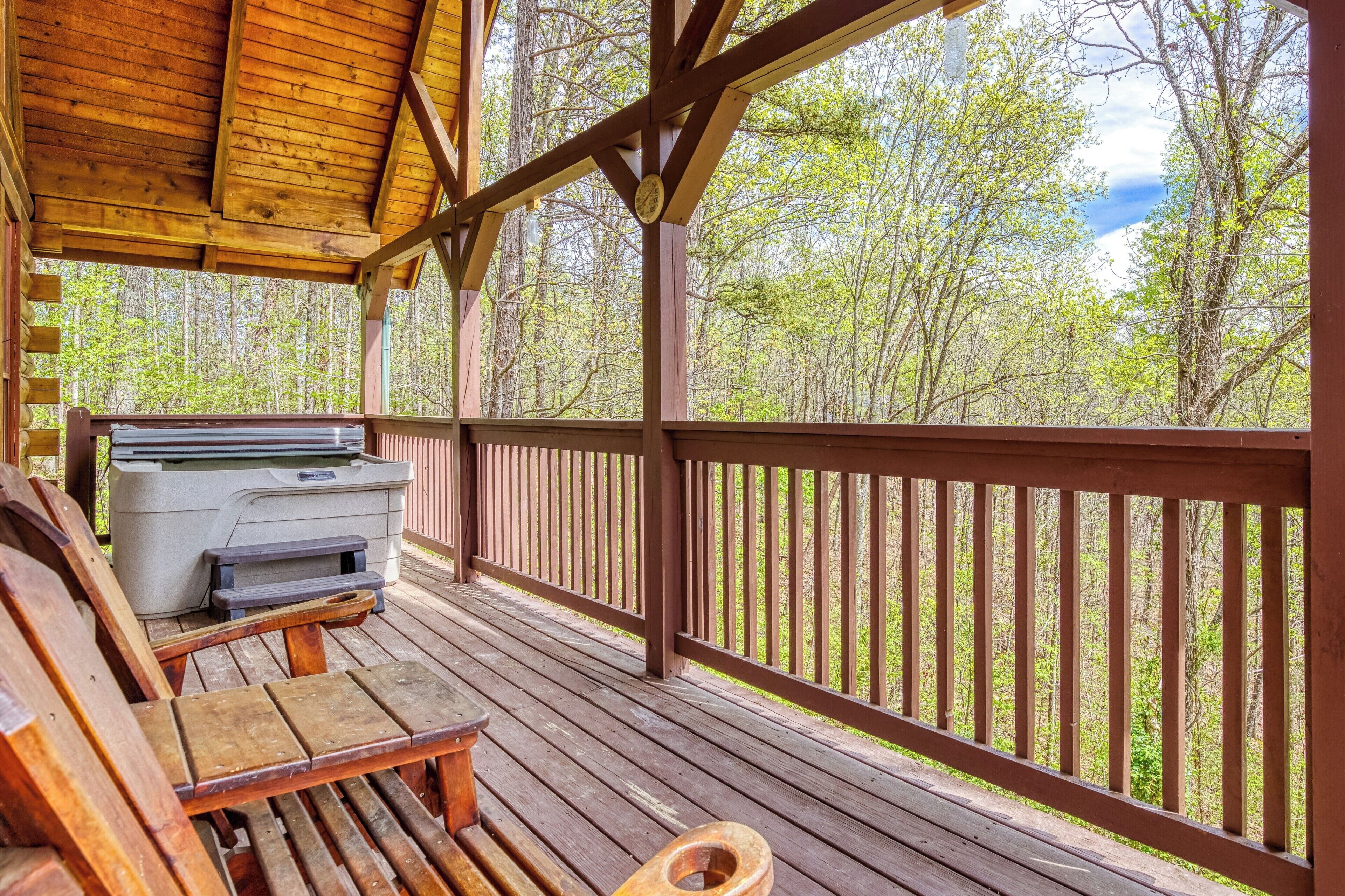 A wooden deck with a grill, a bench, and a toilet.