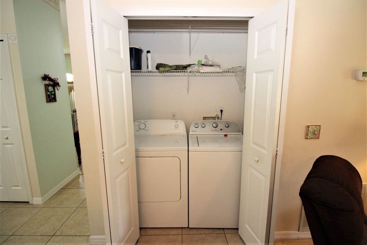 A laundry room with two washing machines and a dryer.